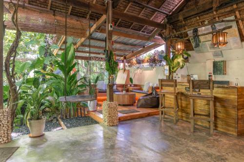 a living room with plants and a bar at Soffta Surf Ranch in General Luna