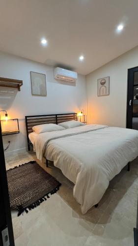 un grand lit dans une chambre avec deux lampes dans l'établissement LODGE ESCOVIEN Strasbourg, à Eschau