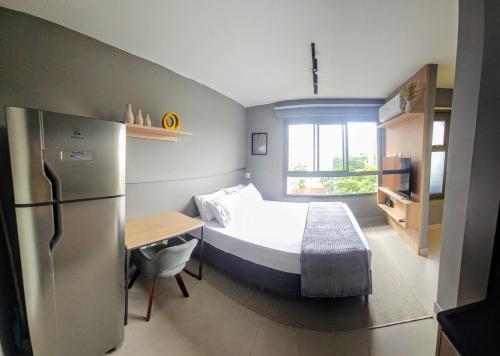 a small bedroom with a bed and a refrigerator at Ap novo, perto de Congonhas, com cama queen size in São Paulo