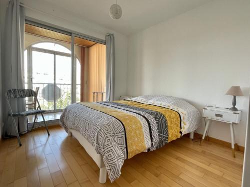 une chambre avec un lit et une grande fenêtre dans l'établissement Spacieux trois pièces avec loggia vitrée et parking sécurisé - FR-1-338-524, à Sète