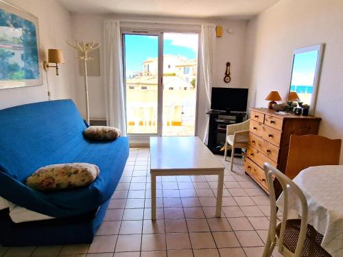 un salon avec un canapé bleu et une table dans l'établissement Studio Climatisé Proche de la Mer avec Parking et Terrasse - Banyuls-sur-Mer - FR-1-309-74, à Banyuls-sur-Mer