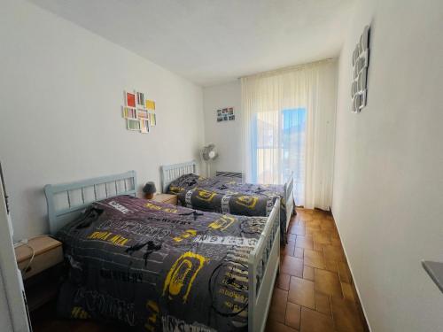 une chambre avec deux lits et une fenêtre dans l'établissement Appartement T3 spacieux, parking, 1ère ligne, 30m de la plage - Argelès-Plage - FR-1-309-242, à Argelès-sur-Mer