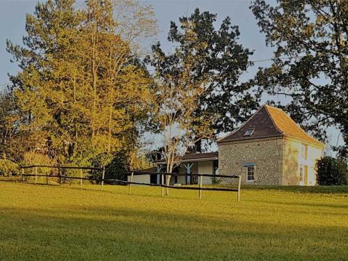 a large field with a building in the background at Maison périgourdine avec jacuzzi, jardin privé et vélos - Idéal 2 personnes, près de Sarlat - FR-1-616-209 in Le Bugue
