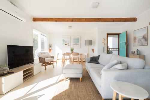 a living room with a couch and a tv at Bayview Cottage - Serene Escape between Beach & Bay in Blairgowrie