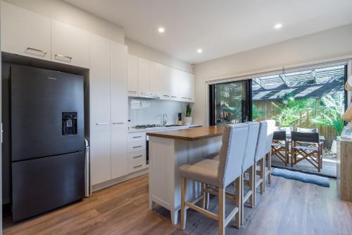 罗斯巴德Villa Morava - Pet-friendly Beachside Comfort的厨房配有白色橱柜和黑色冰箱