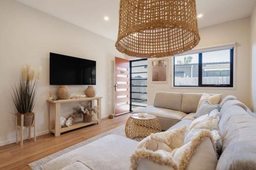 a living room with a couch and a tv at Villa Morava - Dog-friendly Beachside Comfort in Rosebud