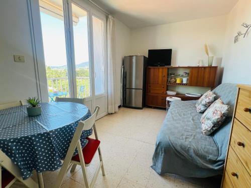 un salon avec une table et une cuisine avec une table et un plateau de table dans l'établissement Argelès: Appartement climatisé proche plage avec balcon, 4 couchages - FR-1-309-386, à Argelès-sur-Mer