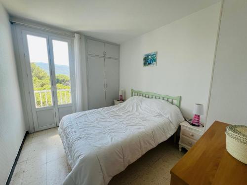 une chambre avec un lit et une grande fenêtre dans l'établissement Argelès: Appartement climatisé proche plage avec balcon, 4 couchages - FR-1-309-386, à Argelès-sur-Mer