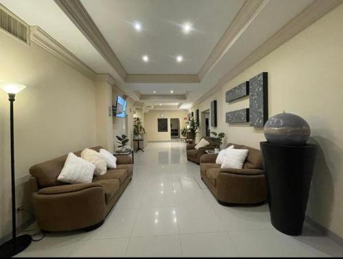 a large living room with couches and a globe on the wall at Hotel Plaza Express in Torreón