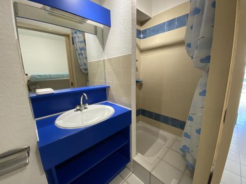 une salle de bain bleue avec un lavabo et un miroir dans l'établissement Studio cabine avec parking privé, proche plage - FR-1-837-11, à Argelès-sur-Mer