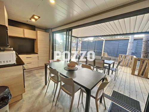 une cuisine et une salle à manger avec une table et des chaises dans l'établissement Chalet de standing à Jullouville - 6 couchages - FR-1-361-568, à Jullouville