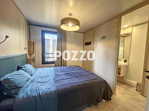 une chambre avec un lit avec une couette bleue dans l'établissement Chalet de standing à Jullouville - 6 couchages - FR-1-361-568, à Jullouville