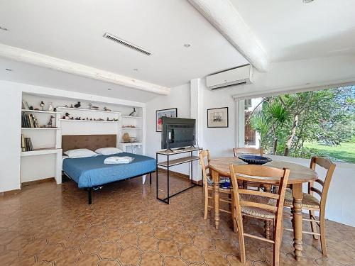 une chambre avec un lit et une table et une salle à manger dans l'établissement Studio calme pour 2 pers avec terrasse privée - FR-1-475-228, à Saintes-Maries-de-la-Mer