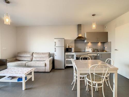 une cuisine et un salon avec une table et des chaises dans l'établissement Appartement F2 avec Terrasse, Piscine Commune, Proche Plage - FR-1-715-106, à Palavas-les-Flots
