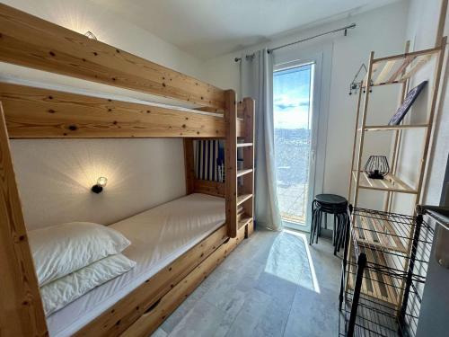une chambre avec un lit superposé et une grande fenêtre dans l'établissement Appartement 3 pièces avec terrasse à Saint-Cyprien - FR-1-225D-225, à Saint-Cyprien