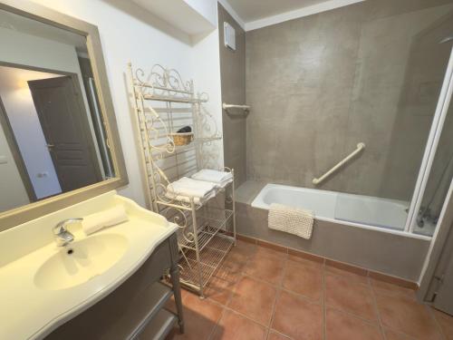 a bathroom with a tub and a sink and a mirror at Appartement climatisé en Provence, à deux pas du Golf de Pont Royal - FR-1-658-35 in Mallemort