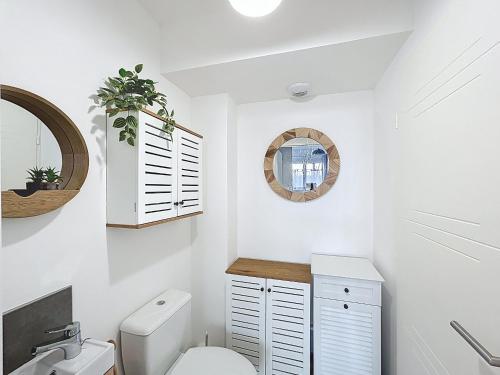 une salle de bain blanche avec des toilettes et un lavabo dans l'établissement Maison Climatisée pour 4 Pers avec Animaux Admis - FR-1-475-224, à Saintes-Maries-de-la-Mer