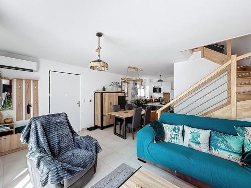 un salon avec un canapé bleu et une table dans l'établissement Maison Climatisée pour 4 Pers avec Animaux Admis - FR-1-475-224, à Saintes-Maries-de-la-Mer