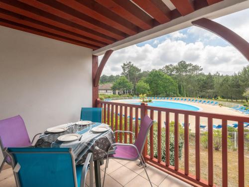 d'un balcon avec une table et des chaises offrant une vue sur la piscine. dans l'établissement Appartement avec balcon et piscine - Golf de Biscarrosse - 4 pers - FR-1-319-616, à Biscarrosse