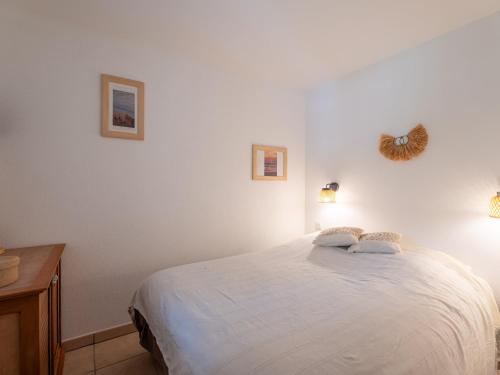 une chambre avec un lit blanc avec deux oreillers dessus dans l'établissement Appartement avec balcon et piscine - Golf de Biscarrosse - 4 pers - FR-1-319-616, à Biscarrosse