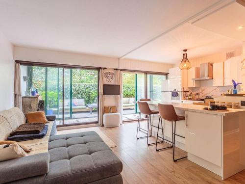 un salon avec un canapé et une cuisine dans l'établissement Bel appartement avec terrasse à Anglet, proche des plages - FR-1-3-628, à Anglet