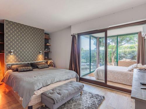 une chambre avec un lit et une grande fenêtre dans l'établissement Bel appartement avec terrasse à Anglet, proche des plages - FR-1-3-628, à Anglet
