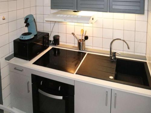 un comptoir de cuisine avec un évier et un mitigeur dans l'établissement Charmant studio rénové 2 pers, centre des Orres - FR-1-322-670, aux Orres