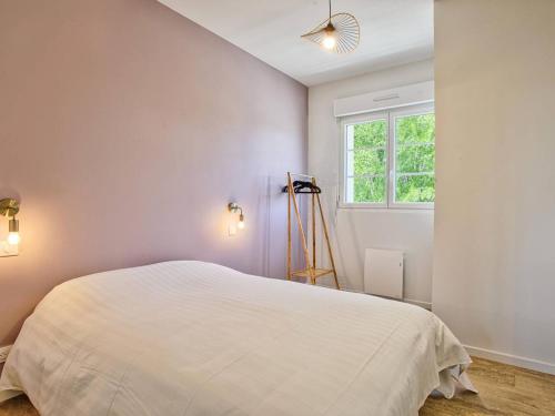 une chambre avec un lit blanc et une fenêtre dans l'établissement Séjour côtier à Merville-Franceville pour 4 personnes, wifi, parking - FR-1-788-72, à Merville-Franceville-Plage