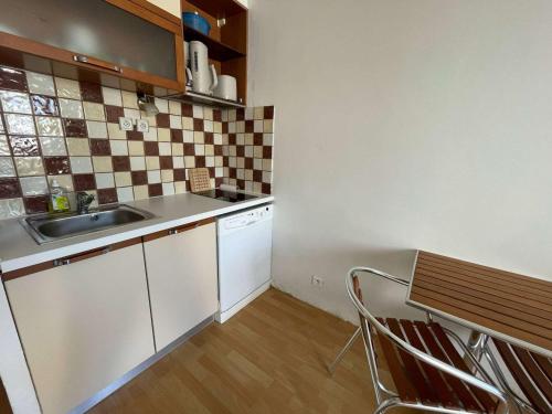 une petite cuisine avec un évier et une table dans l'établissement Studio cabine RDC proche plage avec parking privé - FR-1-328-276, à La Grande Motte