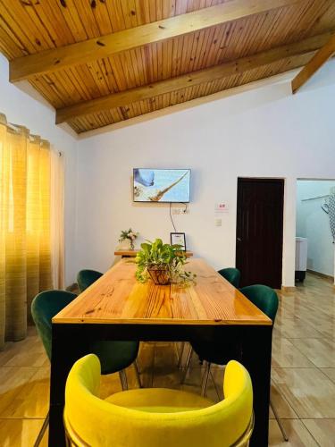 a wooden table with yellow chairs in a room at Apartamento Brisas de la Montaña in Jarabacoa