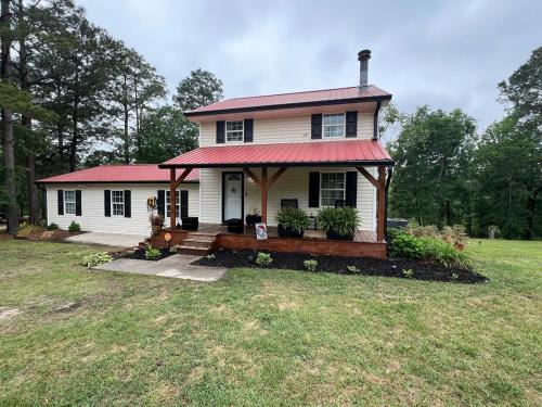a small white house with a red roof at Charming Renovated Home Near Fayetteville, Rustic Retreat for Families in Raeford