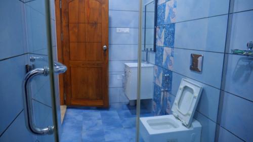 une salle de bain avec toilettes et porte en bois dans l'établissement Dazicor Retreats - Luxury Villa in Kottarakara, 