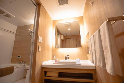 a bathroom with a sink and a mirror at GOLD STAY Nagoya Sakae ゴールドステイ名古屋栄 in Nagoya