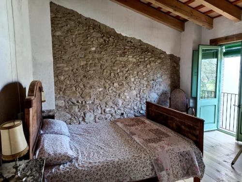 una camera da letto con un letto e un muro di pietra di Rustic Home in Mieres near Banyoles Lake a Mieres