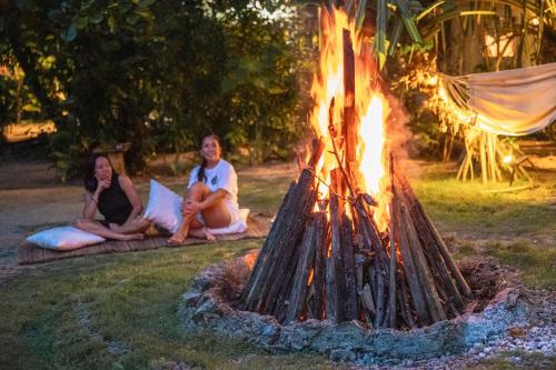 a group of people sitting around a fire at Soffta Surf Ranch in General Luna