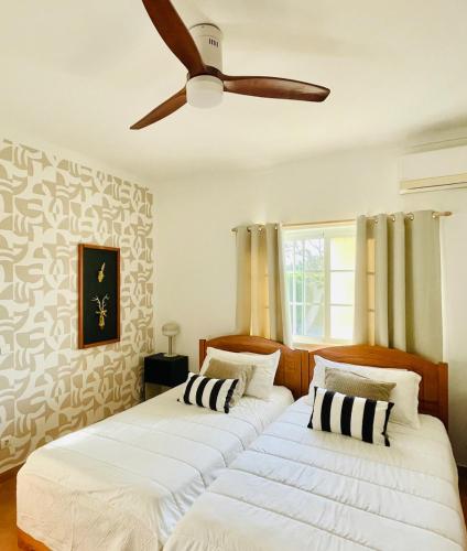 2 Betten in einem Zimmer mit Deckenventilator in der Unterkunft Olive Villa in Alcantarilha