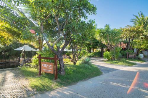 a sign on the side of a road next to a tree at Mayci Boutique Hotel & Restaurant by Amber in Hoi An