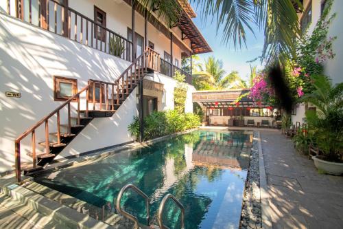 an external view of a house with a swimming pool at Mayci Boutique Hotel & Restaurant by Amber in Hoi An