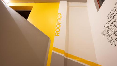 a yellow and white wall with a sign on it at Community Hostel Quito in Quito