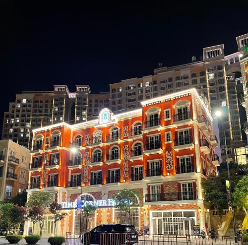um prédio laranja com luzes de natal em frente a um prédio em Times Corner Amalfi Hotel em Duong Dong