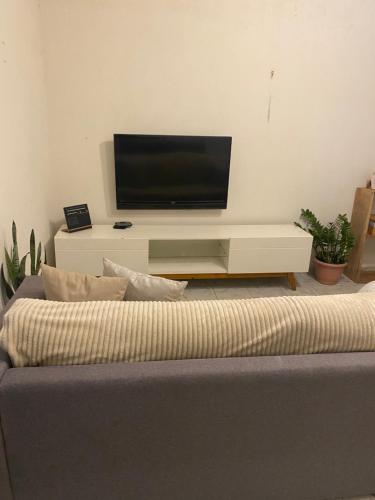 een woonkamer met een tv en een bank bij Casinha 09 in João Pessoa