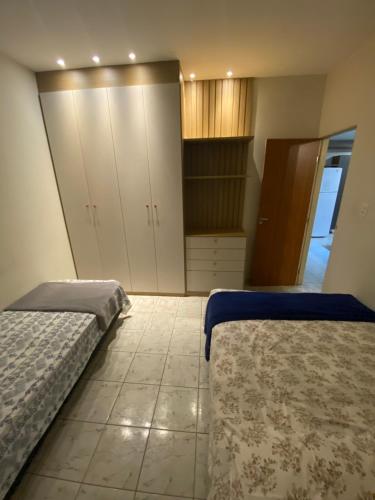 een slaapkamer met 2 bedden en een dressoir en kasten bij Casinha 09 in João Pessoa