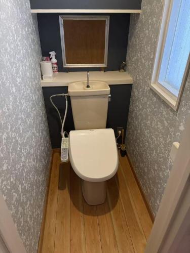 a small bathroom with a white toilet and a window at 箱根 湖と山を望む絶景 in Hakone