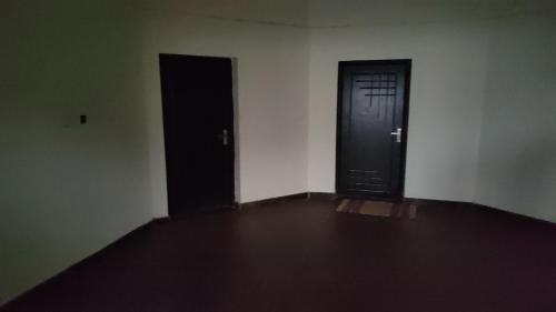 an empty room with two doors on the wall at Ck guest house in Devāla
