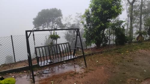 a swing in the rain next to a fence at Ck guest house in Devāla