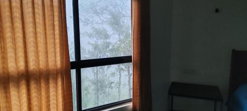 a window with a view of a tree at Ck guest house in Devāla