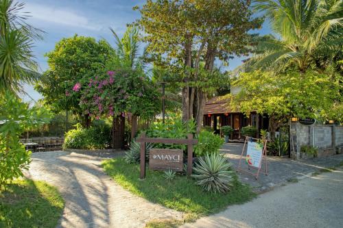 a garden with a bench in front of a house at Mayci Boutique Hotel & Restaurant by Amber in Hoi An