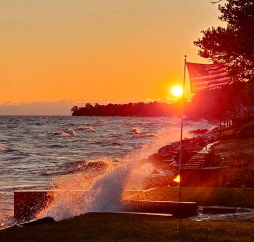 an american flag on the beach at sunset at Tree-Top Lake-Front Cottage in Madison