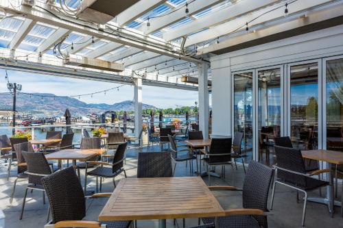 a patio with tables and chairs and windows at Beach Lake Resort in Kelowna