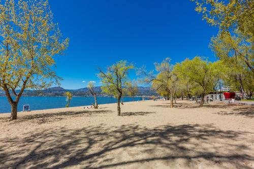 a beach with trees and a body of water at Beach Lake Resort in Kelowna